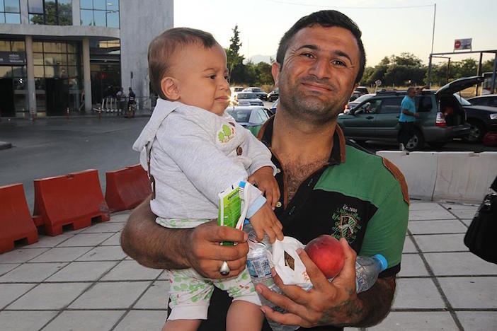 Refugee Solidarity Movement Thessaloniki offers a Syrian refugee and his infant food and basic supplies.